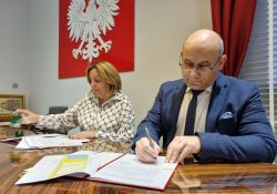 Na zdjęciu prezydent miasta Marcin Witko podpisuje umowę z wykonawca boiska w Białobrzegach. Na zdjęciu gabinet prezydenta i dokumenty na biurku